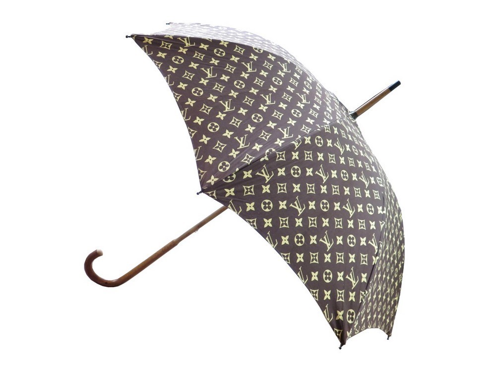 Louis VUITTON : Parapluie en toile Monogram, poignée en résine ambrée, L.  75 cm.